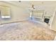 Expansive living area with plush carpeting, a fireplace, bright windows, and a modern ceiling fan at 10680 Sapphire Vista Ave, Las Vegas, NV 89144