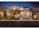Stunning two-story home featuring a spacious driveway, three-car garage, and well-maintained landscaping at twilight at 16 Cresta Villa Ct, Henderson, NV 89011