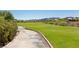 A winding cart path navigates through the lush green fairways of the golf course surrounded by desert landscaping at 16 Cresta Villa Ct, Henderson, NV 89011