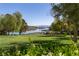 Scenic lake view with lush green lawn and mature trees enhancing the property's tranquility at 16 Cresta Villa Ct, Henderson, NV 89011