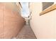 A narrow side yard featuring a brick pathway, secure gate, and neutral-colored walls at 16 Cresta Villa Ct, Henderson, NV 89011