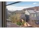 Window view of neighborhood homes with mountain views, complemented by lush green trees in front at 16 Cresta Villa Ct, Henderson, NV 89011