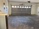 Spacious garage featuring a gray automatic door with window inserts and concrete flooring at 161 Lenape Heights Ave, Las Vegas, NV 89148