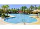 Expansive community pool with palm trees, seating, and water features under a bright blue sky at 161 Lenape Heights Ave, Las Vegas, NV 89148