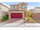 Two-story home with red garage door, desert landscaping, and inviting front entrance at 1783 Matteo Cove Pl, North Las Vegas, NV 89084