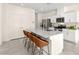 Kitchen island with granite countertops, four bar stools, stainless appliances, and white cabinets at 1783 Matteo Cove Pl, North Las Vegas, NV 89084
