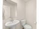 Small powder room with pedestal sink, toilet, mirror, and white walls at 1783 Matteo Cove Pl, North Las Vegas, NV 89084