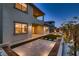 The backyard features a stone patio, an entertainment area, grass accents, and bench seating at 182 Robledo St, Las Vegas, NV 89138