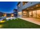 This backyard features an entertainment area, an artificial grass accent, and a stone patio at 182 Robledo St, Las Vegas, NV 89138
