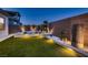 Backyard showing lush turf and desert landscaping with accent lighting at 182 Robledo St, Las Vegas, NV 89138