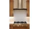 Close up of the stainless steel gas cooktop and range hood in a modern kitchen at 182 Robledo St, Las Vegas, NV 89138