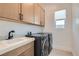 Convenient laundry room features modern washer, dryer, sink, and ample cabinet space at 182 Robledo St, Las Vegas, NV 89138