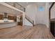 Spacious living room featuring an open kitchen concept, staircase, fireplace, and light wood flooring at 182 Robledo St, Las Vegas, NV 89138