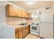 This is the kitchen area with light wood cabinets, white appliances, and tile backsplash at 212 Orland St # 19, Las Vegas, NV 89107