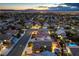 Expansive aerial view of a residential neighborhood with city lights and mountain views in the distance at 2248 Verde Cape Ave, Henderson, NV 89052