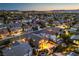 Panoramic aerial view of a neighborhood with many homes and city lights far in the distance at 2248 Verde Cape Ave, Henderson, NV 89052