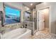 Bright bathroom featuring a soaking tub, glass shower, and tile accents at 2248 Verde Cape Ave, Henderson, NV 89052