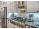 Close-up of modern kitchen appliances including a stainless steel stove with a pot filler faucet at 2248 Verde Cape Ave, Henderson, NV 89052