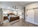 Comfortable main bedroom offers ample space, wood floors, and barn door accents for a rustic-modern touch at 2248 Verde Cape Ave, Henderson, NV 89052
