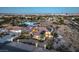 An aerial view shows the lovely home, its well-manicured lawn, a gated driveway, and the Las Vegas skyline at 2780 El Camino Rd, Las Vegas, NV 89146