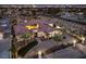 An aerial view of the home with a large circular driveway, mature landscaping and the Las Vegas skyline in the distance at 2780 El Camino Rd, Las Vegas, NV 89146