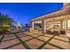 Expansive backyard with a lush lawn, comfortable seating area, outdoor kitchen, and palm trees, ideal for outdoor living at 2780 El Camino Rd, Las Vegas, NV 89146