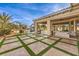 Backyard featuring a pool, lush landscaping, and a covered patio with a built-in grill at 2780 El Camino Rd, Las Vegas, NV 89146