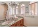 A well-lit bathroom featuring double sinks, granite countertops, wood blinds and decorative artwork at 2780 El Camino Rd, Las Vegas, NV 89146