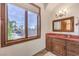Bathroom with a large window, wood vanity, and a view of the backyard and swimming pool at 2780 El Camino Rd, Las Vegas, NV 89146