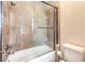 A tiled shower and tub combo feature glass doors in this clean and modern bathroom at 2780 El Camino Rd, Las Vegas, NV 89146