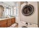 A bathroom features a stackable washer and dryer, double sinks, and a granite countertop at 2780 El Camino Rd, Las Vegas, NV 89146
