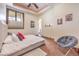 Bright bedroom featuring a large window, tray ceiling, stylish chair, and decorative wall art at 2780 El Camino Rd, Las Vegas, NV 89146