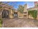 Private courtyard featuring an outdoor fireplace, ornate doors, and mature landscaping at 2780 El Camino Rd, Las Vegas, NV 89146