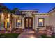 Ornate double door entrance with stone walkway leading to a home surrounded by desert landscaping and small fountain at 2780 El Camino Rd, Las Vegas, NV 89146
