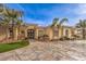 Elegant home exterior with a decorative fountain, lush landscaping, and a textured driveway at 2780 El Camino Rd, Las Vegas, NV 89146