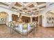 A spacious kitchen featuring barstool seating at a long granite countertop with coffered ceilings and recessed lighting at 2780 El Camino Rd, Las Vegas, NV 89146