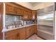 A view of the spacious kitchen with wooden cabinets, stainless steel refrigerator, and granite countertops at 2780 El Camino Rd, Las Vegas, NV 89146