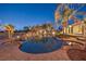 A backyard with a freeform pool, rock features, a playground, and mature landscaping including palm trees at 2780 El Camino Rd, Las Vegas, NV 89146