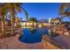 A backyard with a freeform pool, waterfall feature, and mature landscaping including palm trees at 2780 El Camino Rd, Las Vegas, NV 89146