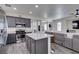 Modern kitchen with gray cabinets, stainless steel appliances, and a center island overlooking the living area at 2929 Salado Creek Ave, North Las Vegas, NV 89081