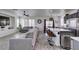 Open-concept living room with a large gray sectional sofa, ceiling fan, and seamless flow into the kitchen at 2929 Salado Creek Ave, North Las Vegas, NV 89081