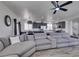 Expansive living room with recessed lighting, large windows, and gray sectional sofa open to kitchen and dining area at 2929 Salado Creek Ave, North Las Vegas, NV 89081