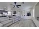 Open-concept living room with gray sofa and hardwood floors, connecting to kitchen at 2929 Salado Creek Ave, North Las Vegas, NV 89081