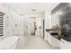 Elegant bathroom with a soaking tub, glass shower, and dual vanity with black marble countertops at 366 Rancho La Costa St, Las Vegas, NV 89138