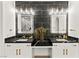 Modern bathroom with black marble backsplash, dual sinks, white cabinets, and gold fixtures at 366 Rancho La Costa St, Las Vegas, NV 89138