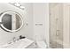 Bright bathroom featuring a modern vanity with a circular mirror and a glass-enclosed shower at 366 Rancho La Costa St, Las Vegas, NV 89138