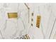 Close-up of a luxurious shower with gold hardware and elegant marble tile at 366 Rancho La Costa St, Las Vegas, NV 89138
