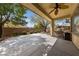 A covered patio with a ceiling fan overlooks a large, well maintained backyard with desert landscaping at 4217 Box Canyon Falls Ave, North Las Vegas, NV 89085