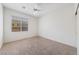 Bright bedroom with neutral carpet, ceiling fan, and window with blinds, offering a simple and comfortable living space at 4217 Box Canyon Falls Ave, North Las Vegas, NV 89085