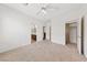 Bright bedroom with neutral carpet, featuring access to a bathroom and walk-in closet, plus a ceiling fan at 4217 Box Canyon Falls Ave, North Las Vegas, NV 89085